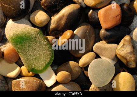 Pietre arrotondate su di una spiaggia di ciottoli di luce del sole di mattina Abstract closeup texture di sfondo Foto Stock