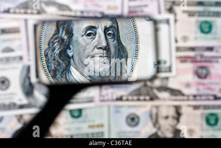 Una lente di ingrandimento è usato per mostrare il ritratto di Benjamin Franklin come visto l'americano su un centinaio di dollari. Foto Stock