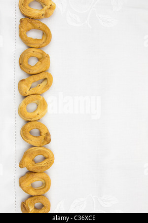 Tovaglia cucina sfondo con una fila di taralli, buona copia spazio per il testo Foto Stock