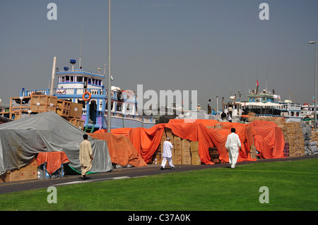Il carico delle merci sul Dhow Trading sul Dubai Creek, Deira, Dubai, Emirati Arabi Uniti Foto Stock