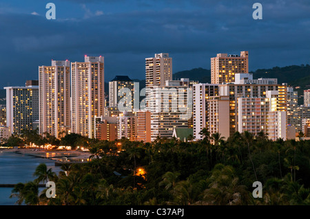 Un elevato angolo di vista crepuscolo di Kapiolani Beach Park e il alto-aumento alberghi lungo il litorale di Waikiki, Honolulu, Hawaii. Foto Stock