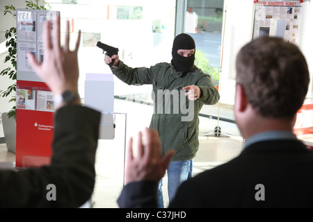 Esercizio di polizia. Rapina in banca. Bank Robber con una pistola tiene ostaggi in una banca. Foto Stock