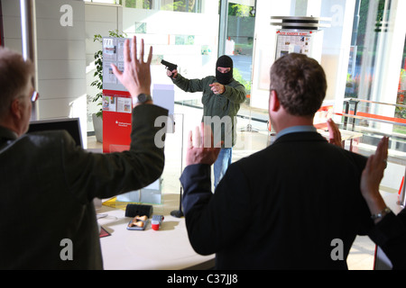 Esercizio di polizia. Rapina in banca. Bank Robber con una pistola tiene ostaggi in una banca. Foto Stock