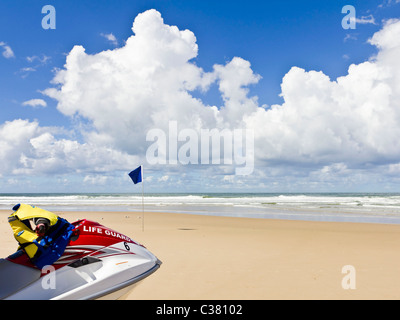 Bagnino di spiaggia la barca di salvataggio sulla sabbia con le onde e raccogliere tempesta Foto Stock