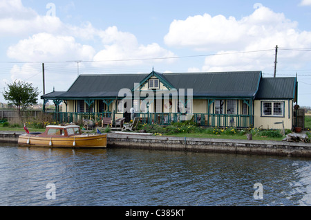 Casa con la giornata in barca sul fiume Thurne vicino a Potter Heigham su Norfolk Broads, East Anglia, Inghilterra. Foto Stock