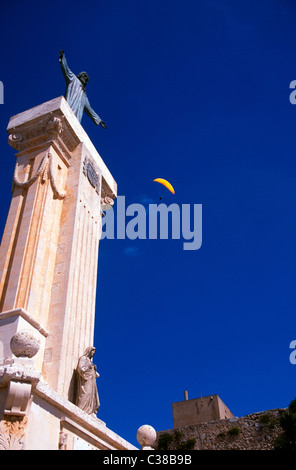 Deltaplano sulla statua di Cristo sul Monte Toro al di sopra di Es Mercadal durante un festival di isola di Menorca, Spagna Foto Stock