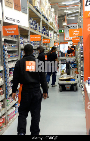 B&Q personale restockign ripiani in una vernice isle. Foto Stock