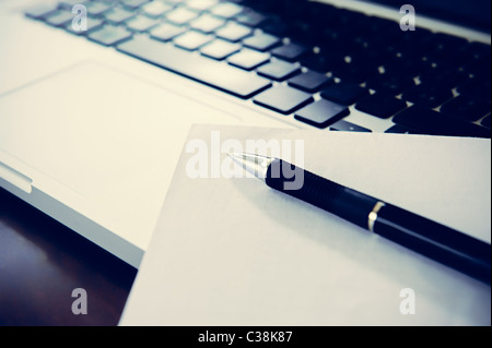 Withe carta sul computer portatile con penna, concetto di videoscrittura. Foto Stock