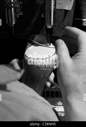 Una pinta di Guinness che viene tirata in Sissy McGintys Pub, Castlerea, nella contea di Roscommon, Irlanda Foto Stock