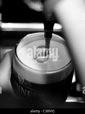 Una pinta di Guinness che viene tirata in Tully's Hotel Bar, Castlerea, nella contea di Roscommon, Irlanda. Foto Stock