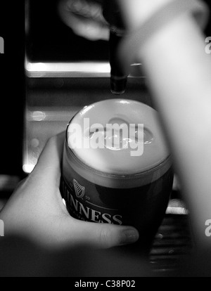 Una pinta di Guinness che viene tirata in Tully's Hotel Bar, Castlerea, nella contea di Roscommon, Irlanda. Foto Stock