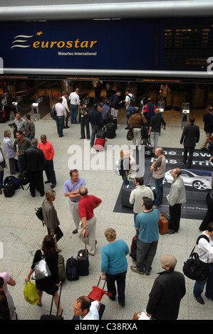 Pendolari attendere il loro treno nella vecchia International Terminal Eurostar a Londra Waterloo. Foto Stock