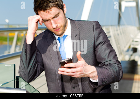 Uomo che cammina con il telefono cellulare Foto Stock