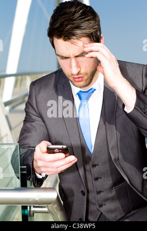 Uomo che cammina con il telefono cellulare Foto Stock