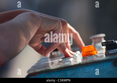 Le dita femminili e le mani delicate di un operatore Ride Control premendo i pulsanti di controllo al parco divertimenti Blackpool Pleasure Beach, Lancashire, Regno Unito Foto Stock