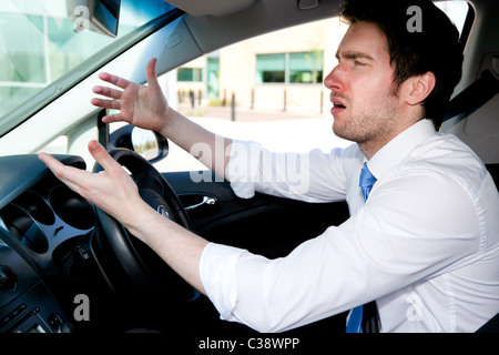 L'uomo gesticolando durante la guida di auto Foto Stock