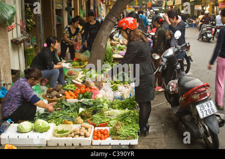 Vista orizzontale del caos disorganizzato su una strada della città vecchia di Hanoi con frutta e verdura si spegne il rivestimento delle pavimentazioni. Foto Stock