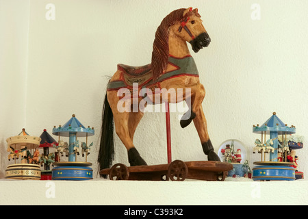 Un assortimento di collezione di vecchi giocattoli, un cavallo di legno e giostre Foto Stock