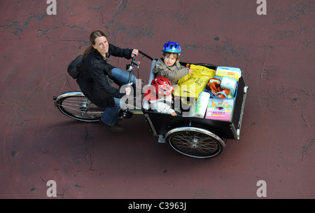 Una donna con due bambini su un cargo bike Foto Stock