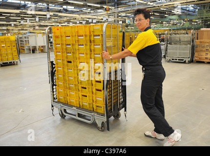 Un dipendente con un carrello in un centro di smistamento postale, Berlino, Germania Foto Stock