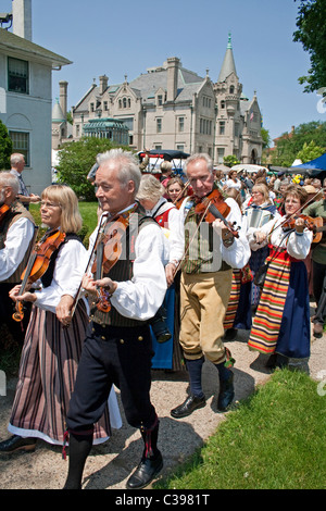 Sfilata Spelmanslag fiddlers per Midsommar celebrazione con l'Istituto svedese in background. Minneapolis Minnesota MN USA Foto Stock