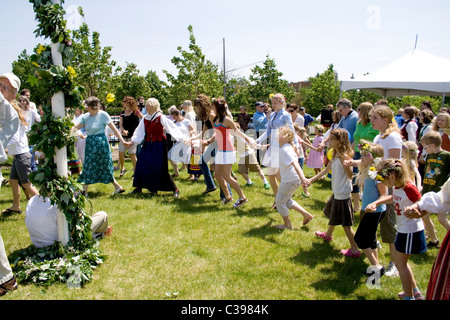 Gruppo celebrando estate dal cerchio ballando intorno il Maypole presso l'Istituto Svedese Midsommar. Minneapolis Minnesota MN USA Foto Stock