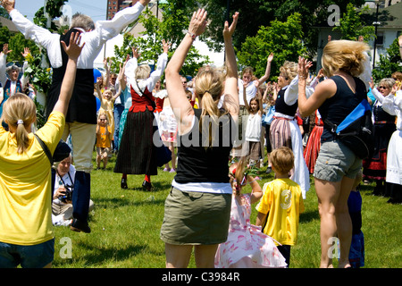 Maypole circle dance celebranti jumping durante Midsommar Celebrazione presso l'Istituto svedese. Minneapolis Minnesota MN USA Foto Stock