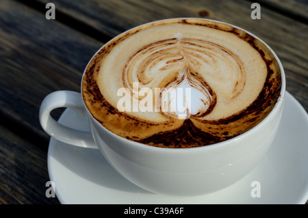 Tazza di soffice schiuma di latte caldo per caffè cappuccino sul tavolo  bianco con divano sfocate in background Foto stock - Alamy