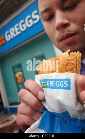 L'immagine mostra: un lavoratore della città di mangiare a Greggs pasty. Foto Stock