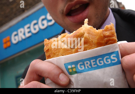 L'immagine mostra: un lavoratore della città di mangiare a Greggs pasty. Foto Stock