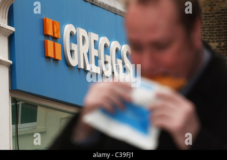 L'immagine mostra: un lavoratore della città di mangiare a Greggs pasty. Foto Stock