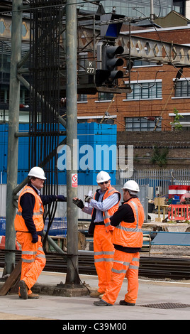 Ingegneri al lavoro sotto una casella segnale alla stazione di King Cross a Londra. Foto Stock