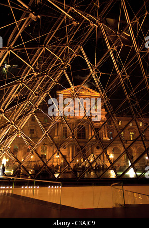 Il Palazzo del Louvre e l'atrio dall'interno della piramide di vetro del museo di notte, Parigi Foto Stock