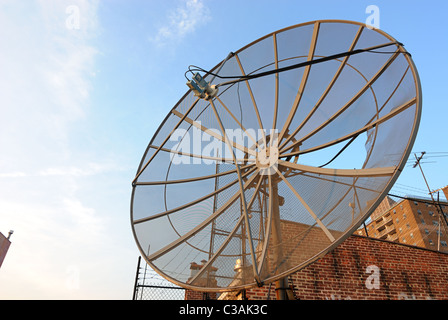 Vista da un tetto in New York City con un vecchio usurato parabola satellitare ricevitore Foto Stock
