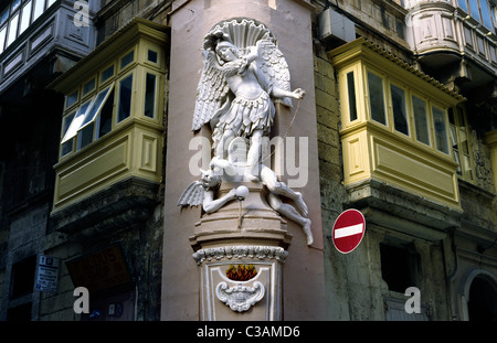 L'arcangelo Michele trampels Satana (guerra in cielo) santuario su un angolo di strada nella capitale Maltese di La Valletta. Foto Stock