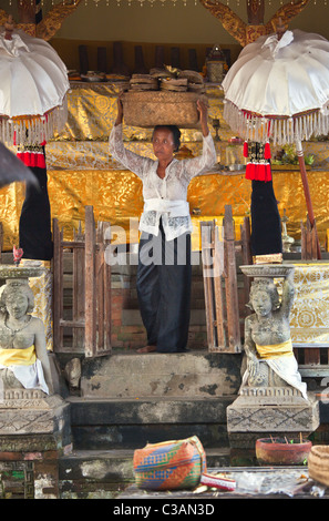 Una donna balinese che trasportano offerte presso il tempio indù di pura SAMUANTIGA - PETULU, Bali, Indonesia Foto Stock