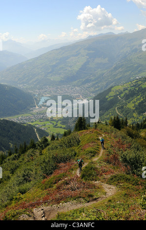 Due mountain bike cavalcare un sentiero di cresta giù per la montagna verso la città di Bourg-Saint-Maurice nelle Alpi francesi. Foto Stock