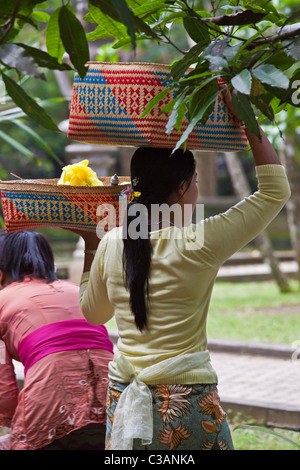 Donna balinese portano cesti con offerte di indù alla pura Tirta Empul complesso tempio - TAMPAKSIRING, Bali, Indonesia Foto Stock