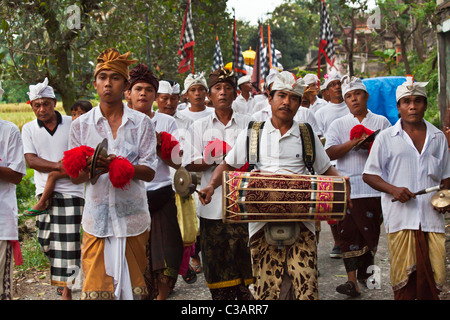 Tamburi e cembali vengono riprodotti durante una processione indù per un tempio anniversario - Ubud, Bali Foto Stock