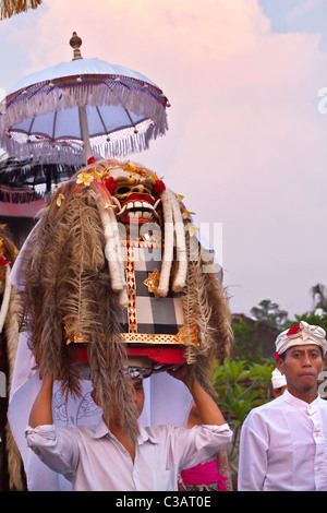 Un leone maschera usata nella tradizionale danza LEGONG sono portati durante una processione indù per un tempio anniversario - Ubud, Bali Foto Stock