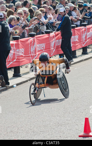 Paolo Rea uomini carrozzella concorrente nella maratona di Londra guardato dalla folla. 2011 Foto Stock