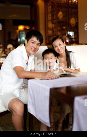 Ritratto di una famiglia felice guardando attraverso un menu Foto Stock