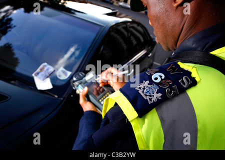 Un vigile emette un biglietto di parcheggio Foto Stock