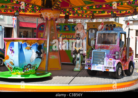 Un giovane bambino a cavallo di una giostra Merry Go Round, Wallingford, Oxfordshire, Regno Unito Foto Stock