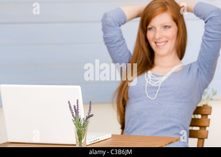 Terrazza estiva redhead donna con notebook in giardino Foto Stock