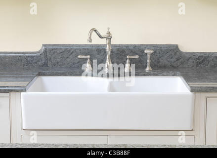 Doppia casa colonica francese lavandino con la ceramica anteriore esposto e impostata su un piano di lavoro in granito con drainer scanalato su entrambi i lati Foto Stock