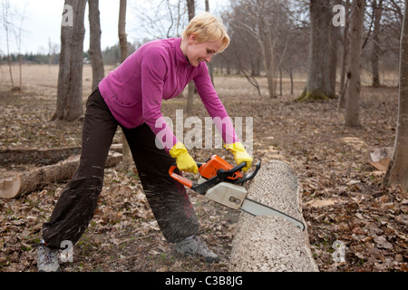 Felice emotiva donna caucasica Registro di taglio con sega a nastro Foto Stock