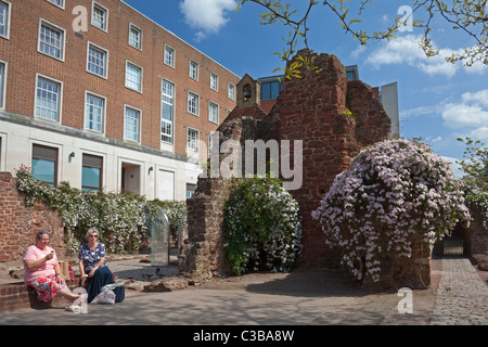Due donne godendo di un gelato accanto ai resti delle mura della città, Exeter Devon Foto Stock