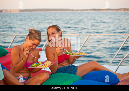 Due donne mangiare sul ponte dello yacht Foto Stock