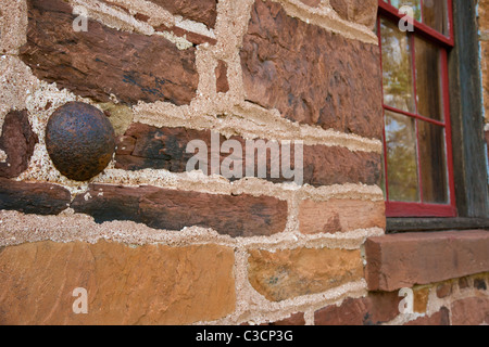 Palla di cannone incorporata nella parete della storica casa in pietra con una finestra che riflette la Manassas National Battlefield. Foto Stock